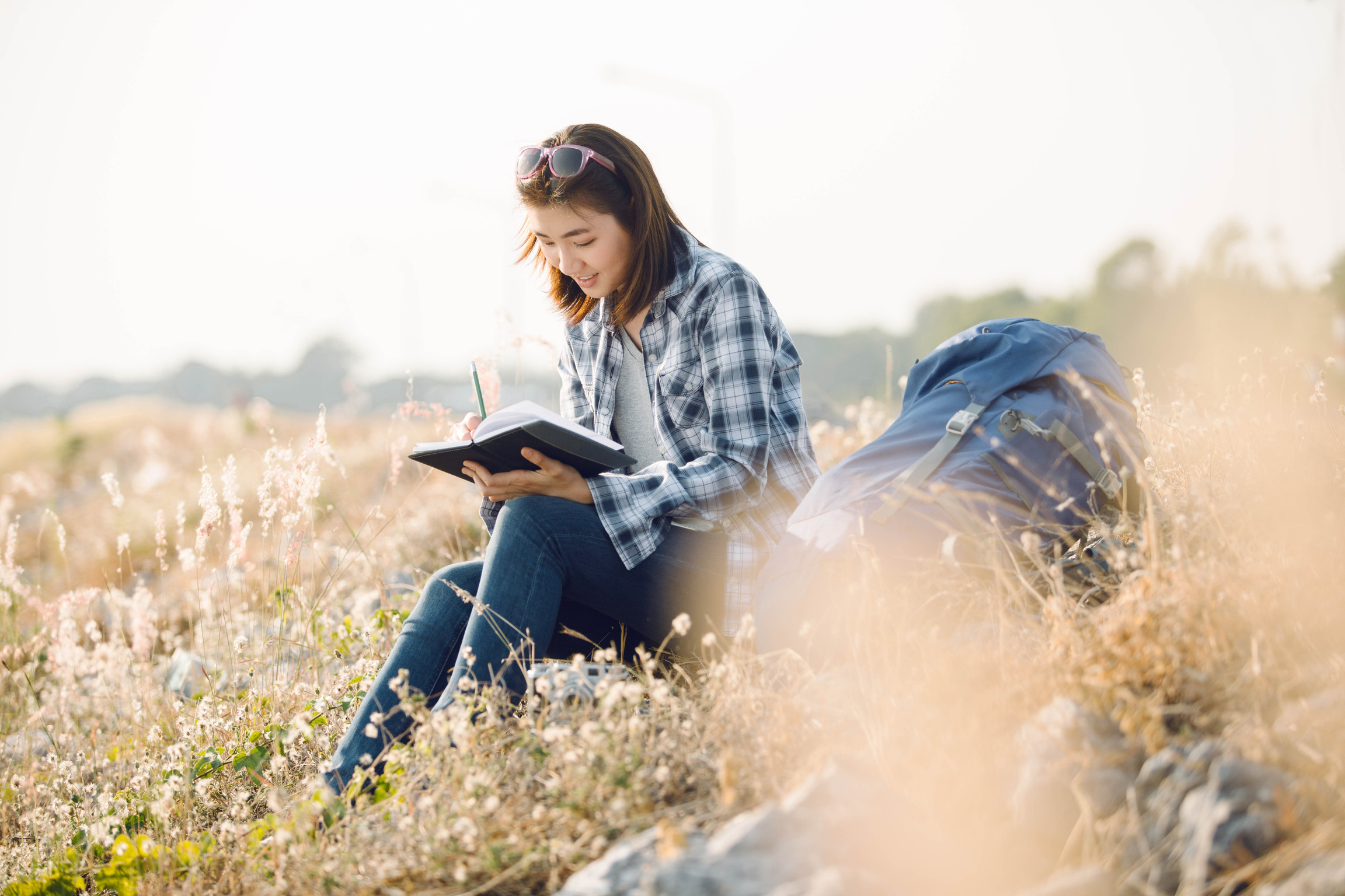 Beautiful Young Asia Woman Writing on a Journal about Her Hiking Trip,Flare Light